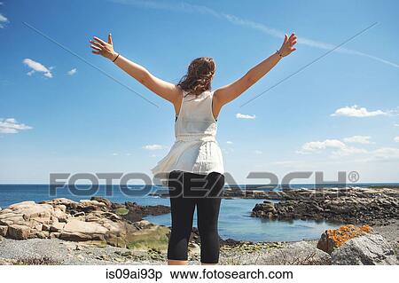 Rear view of young woman at the rocky coastal beach in Biddeford, Maine, USA View Large Photo Image Stock Photography - Rear view of young woman at the rocky coastal beach in Biddeford, Maine, USA. Fotosearch