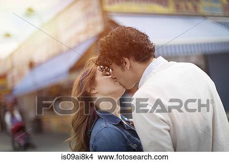 Picture - Romantic couple kissing at amusement park. Fotosearch