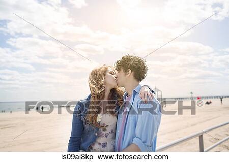 Stock Photography - Romantic couple kissing at beach. Fotosearch