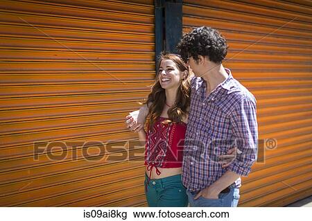 Stock Image - Romantic couple strolling with arms around each other. Fotosearch