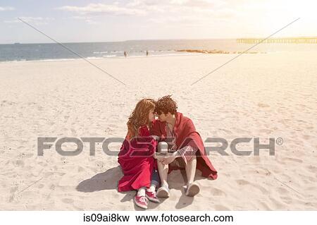 Romantic couple wrapped in blankets at beach View Large Photo Image Stock Photo - Romantic couple wrapped in blankets at beach. Fotosearch