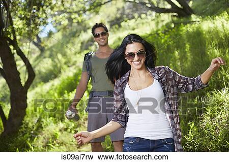 Smiling couple walking in woodlands View Large Photo Image Stock Photo - Smiling couple walking in woodlands. Fotosearch