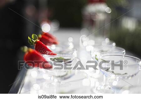 Stock Image - Strawberry slice on cocktail glasses. Fotosearch