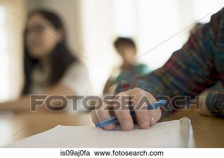 Stock Image - Student holding pen, close up. Fotosearch