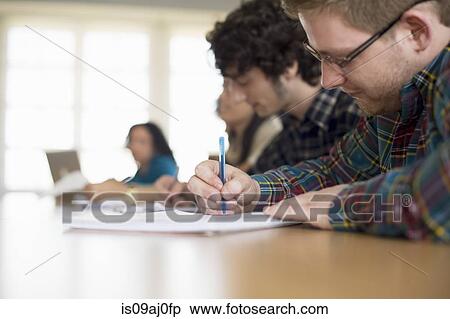 Stock Photography - Students writing in classroom. Fotosearch