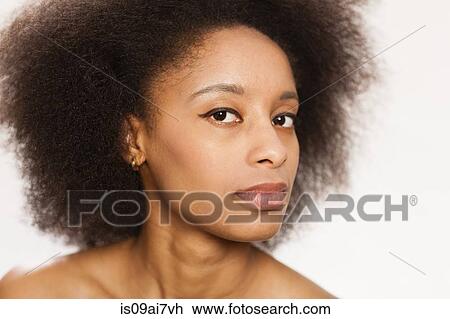 Stock Image - Studio shot of young woman with afro. Fotosearch
