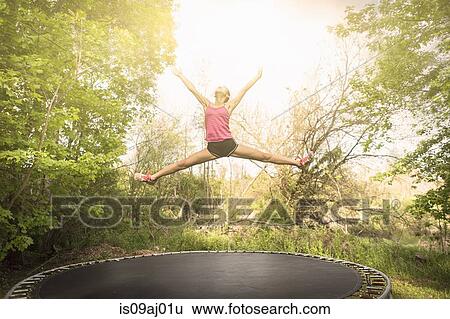 Teenage girl doing star jump on trampoline, outdoors View Large Photo Image Stock Photograph - Teenage girl doing star jump on trampoline, outdoors. Fotosearch