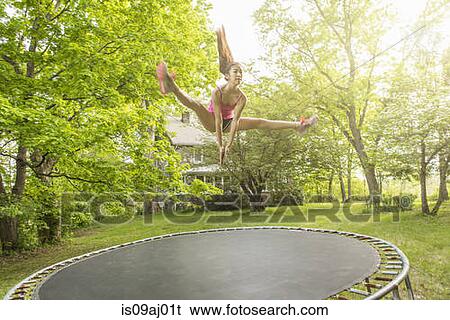 Teenage girl jumping on trampoline, outdoors View Large Photo Image Stock Photograph - Teenage girl jumping on trampoline, outdoors. Fotosearch