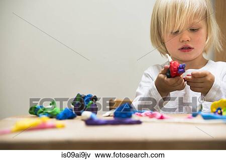 Stock Photo - Three year old boy playing with modeling clay. Fotosearch