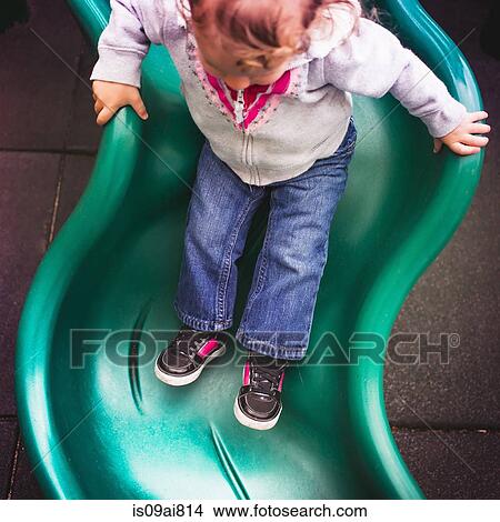 Toddler going down slide in playground View Large Photo Image Picture - Toddler going down slide in playground. Fotosearch