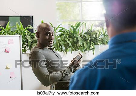Two male business colleagues meeting in office View Large Photo Image Stock Photo - Two male business colleagues meeting in office. Fotosearch