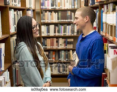 Stock Image - Young couple in library. Fotosearch