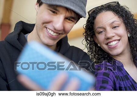 Young couple photographing themselves View Large Photo Image Stock Image - Young couple photographing themselves. Fotosearch