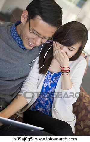 Young couple using digital tablet, laughing View Large Photo Image Stock Photography - Young couple using digital tablet, laughing. Fotosearch