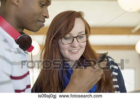 Stock Image - Young couple using smartphone. Fotosearch