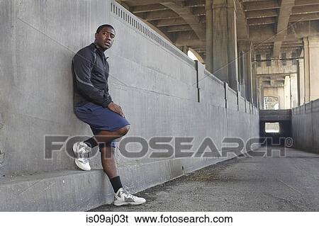 Young male runner taking a break on city bridge View Large Photo Image Stock Photograph - Young male runner taking a break on city bridge. Fotosearch