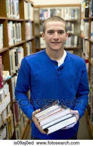 Young man holding books View Large Photo Image Stock Image - Young man holding books. Fotosearch