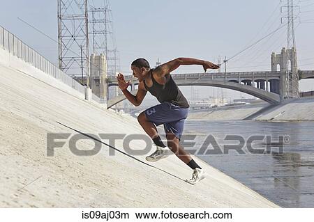 Young man speed running up riverbank View Large Photo Image Picture - Young man speed running up riverbank. Fotosearch