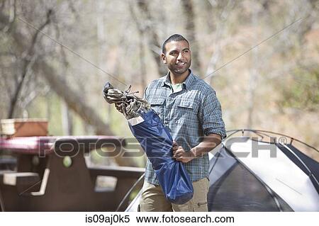Stock Photography - Young man unpacking equipment on campsite, Sedona, Arizona, USA. Fotosearch