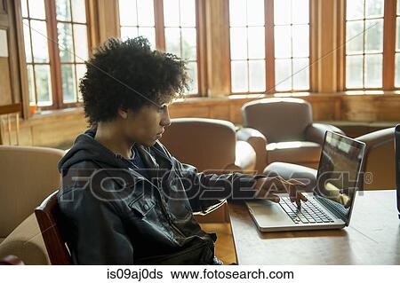 Stock Photograph - Young man using laptop. Fotosearch