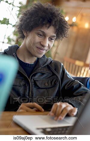 Stock Photography - Young man using laptop. Fotosearch