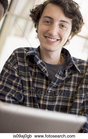 Young man wearing checked shirt, smiling View Large Photo Image Stock Image - Young man wearing checked shirt, smiling. Fotosearch