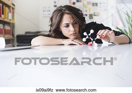 Stock Photo - Young woman contemplating molecular model of Ethanol molecule. Fotosearch
