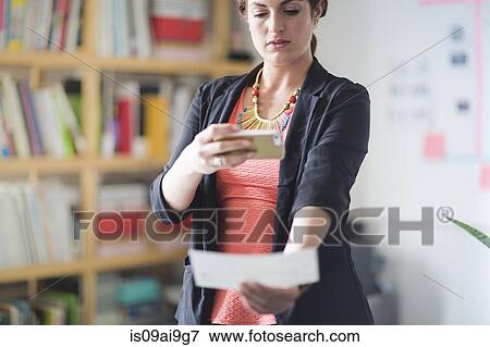 Stock Photo - Young woman depositing cheque with smartphone. Fotosearch