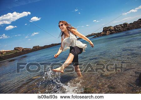 Young woman in the sea at the rocky coastal beach in Biddeford, Maine, USA View Large Photo Image Stock Photograph - Young woman in the sea at the rocky coastal beach in Biddeford, Maine, USA. Fotosearch