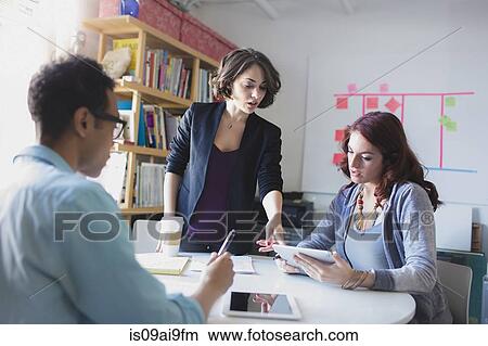 Young woman leading small meeting View Large Photo Image Picture - Young woman leading small meeting. Fotosearch
