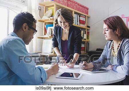 Young woman leading small meeting View Large Photo Image Stock Image - Young woman leading small meeting. Fotosearch