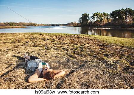 Young woman sunbathing on grass in Kittery, Maine, USA View Large Photo Image Stock Photo - Young woman sunbathing on grass in Kittery, Maine, USA. Fotosearch