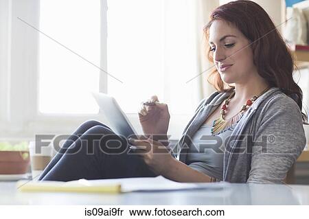 Young woman using digital tablet at coffee break View Large Photo Image Stock Photography - Young woman using digital tablet at coffee break. Fotosearch