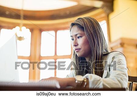 Stock Photograph - Young woman using laptop. Fotosearch