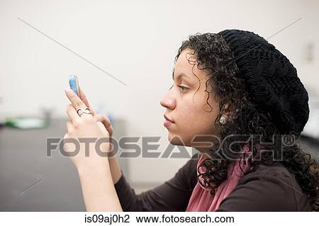 Stock Image - Young woman using smartphone. Fotosearch