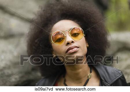 Young woman wearing round sunglasses View Large Photo Image Stock Image - Young woman wearing round sunglasses. Fotosearch