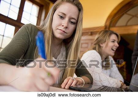 Stock Image - Young woman writing. Fotosearch
