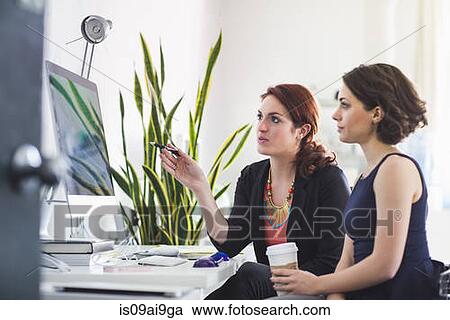 Young women chatting in front of computer View Large Photo Image Stock Image - Young women chatting in front of computer. Fotosearch