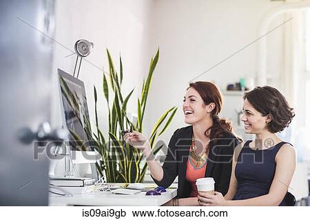 Young women chatting in front of computer View Large Photo Image Stock Image - Young women chatting in front of computer. Fotosearch