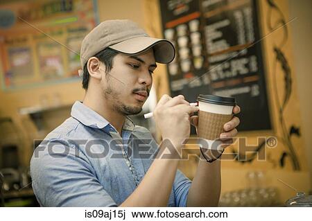 Barista writing on disposable cup in cafe View Large Photo Image Stock Image - Barista writing on disposable cup in cafe. Fotosearch