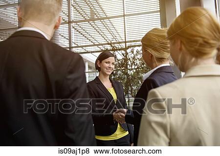 Business team greeting young female business client View Large Photo Image Stock Photo - Business team greeting young female business client. Fotosearch