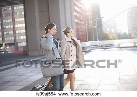 Picture - Businessman and woman walking across city rooftop parking lot. Fotosearch