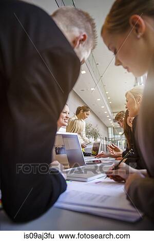 Businessmen and businesswomen at brainstorming meeting View Large Photo Image Stock Photograph - Businessmen and businesswomen at brainstorming meeting. Fotosearch
