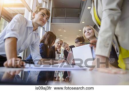 Stock Photography - Businessmen and businesswomen at brainstorming meeting. Fotosearch