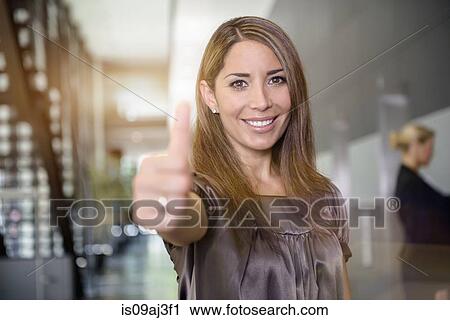 Stock Image - Businesswoman giving the thumbs-up. Fotosearch