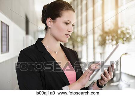 Stock Image - Businesswoman in office using digital tablet. Fotosearch