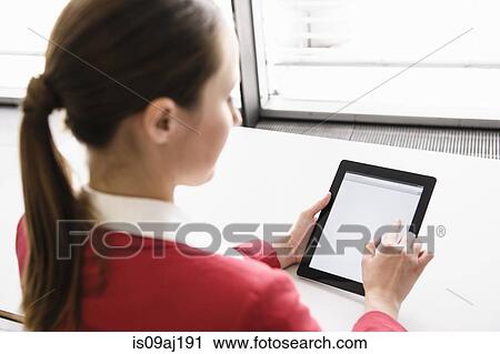 Stock Image - Businesswoman using digital tablet touchscreen in office. Fotosearch