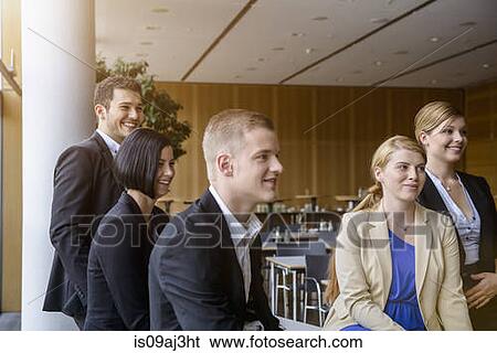 Businesswomen and men listening at business meeting in office View Large Photo Image Stock Photograph - Businesswomen and men listening at business meeting in office. Fotosearch