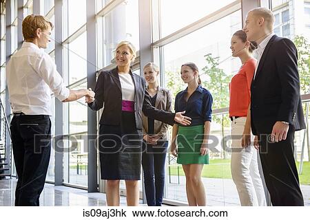 Stock Image - Businesswomen and men meeting client in office. Fotosearch