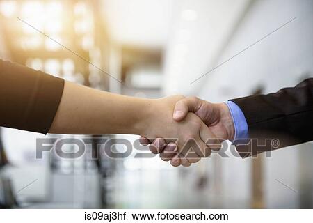 Close up of businesswomen and businessman shaking hands in office View Large Photo Image Stock Image - Close up of businesswomen and businessman shaking hands in office. Fotosearch